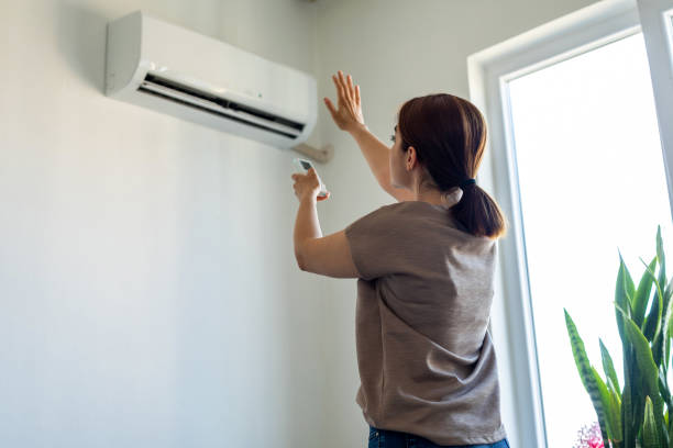 mujer comprobando aire acondicionado split que no enfria por fuga de gas